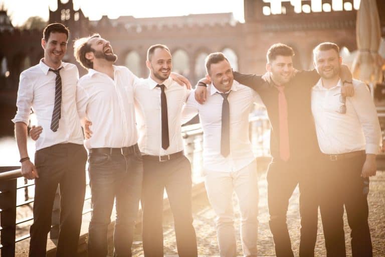 A nostalgic scene of friends in classic attire sharing happiness outdoors.