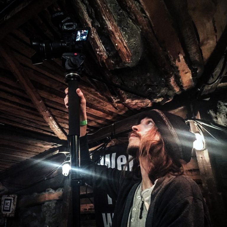 The vintage-style photographer reaches up with passion to capture the perfect shot in the intimate,.