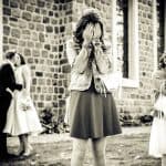 The vintage-style photo captures the raw emotion of a wedding day, with the bride and guests experie.