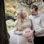 The vintage-style image captures the emotional moment of a pregnant woman and her partner sharing lo.