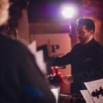 The image captures the emotional connection between the pianist and the audience in a retro setting.