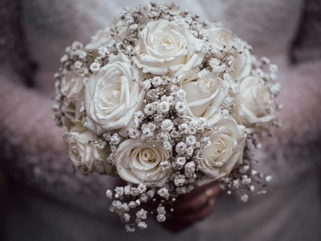 The vintage-inspired bridal bouquet with white roses and baby's breath evokes pure elegance and hear.