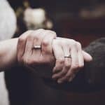 The vintage-style image captures the emotional moment of the two hands gently clasped together, symb.