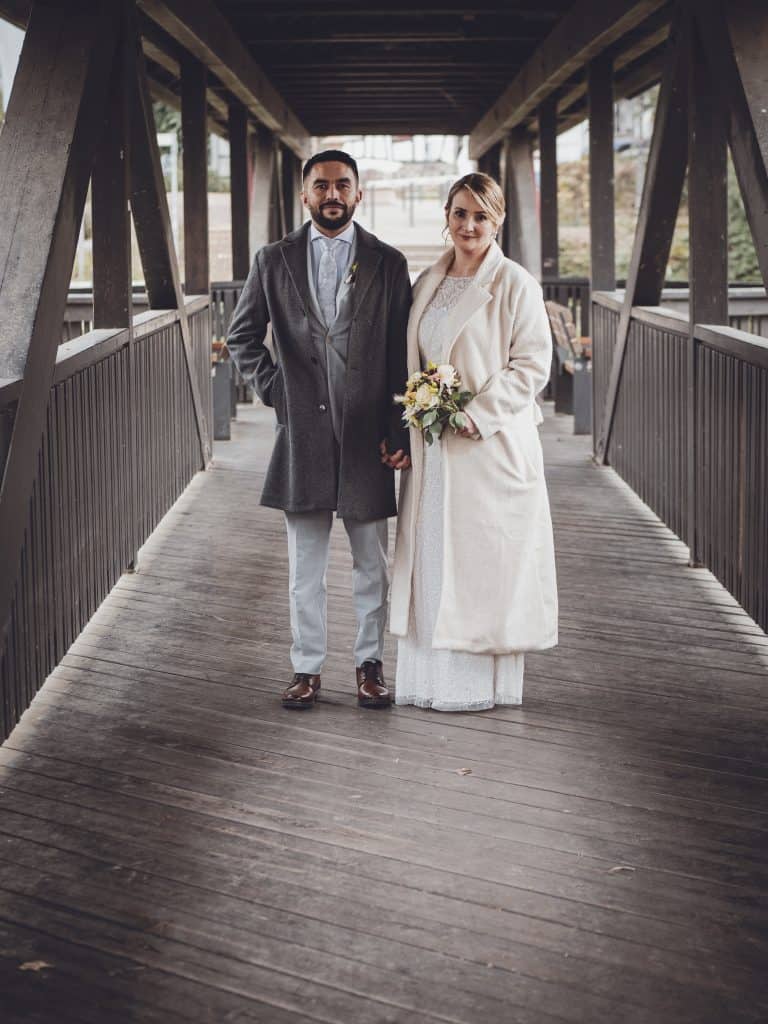 A heartfelt vintage wedding photo of the couple standing on a bridge, symbolizing love and new beginnings.
